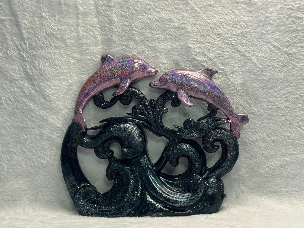 Example finished resin pour: holographic dolphins above navy glitter waves on a neutral background.