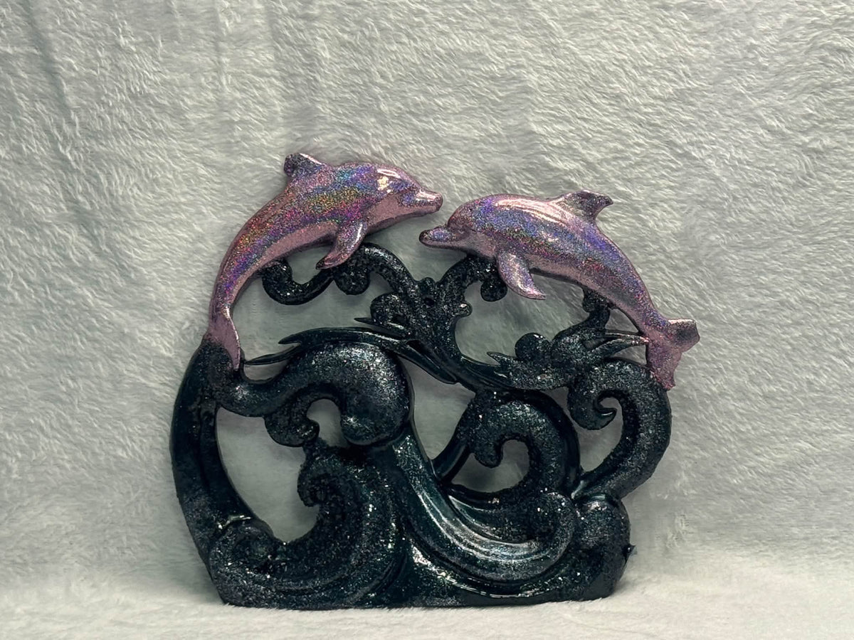 Example finished resin pour: holographic dolphins above navy glitter waves on a neutral background.