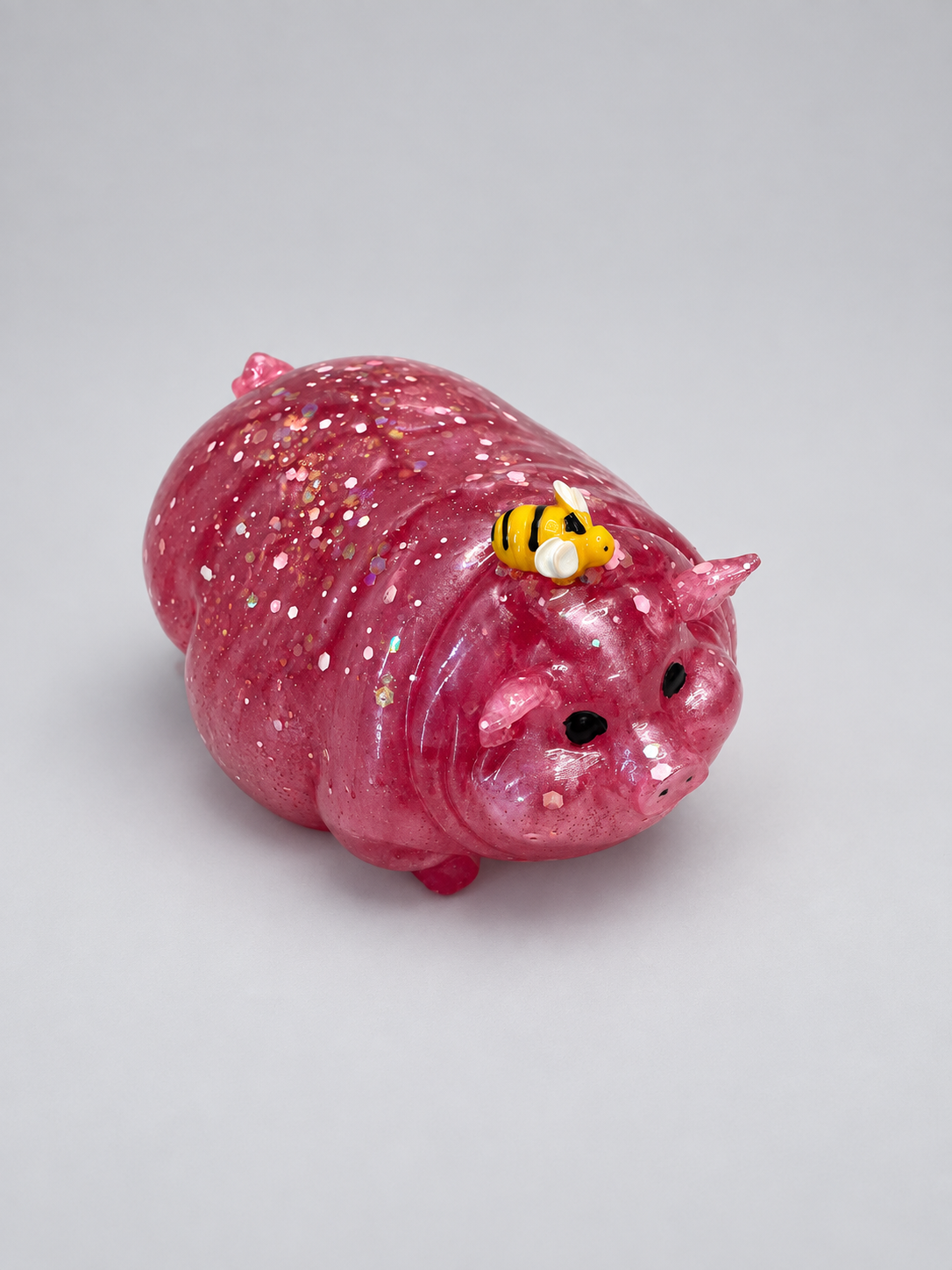 Finished sparkly pink pig with a tiny bee made from a resin mold