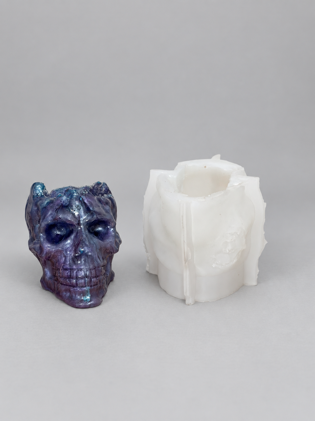 Front view of Druzy Skull resin casting beside the silicone mold