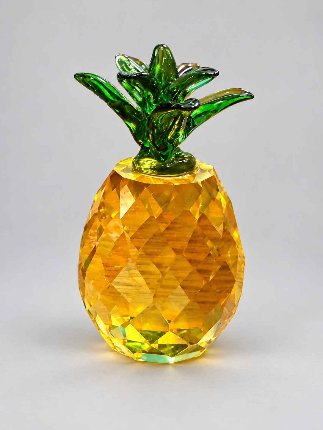 Finished glossy golden faceted pineapple with green leafy crown made from a resin mold
