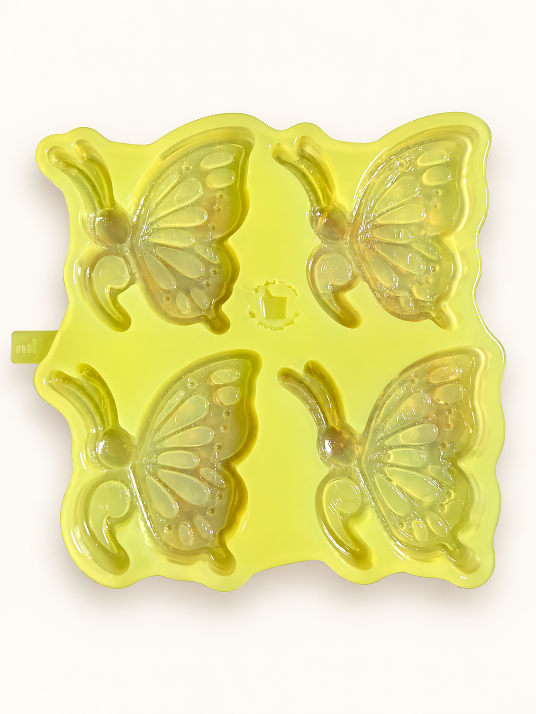 Four-cavity semicolon butterfly mold on a neutral background