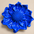 Blue sunflower mold dish on a neutral background, overhead view