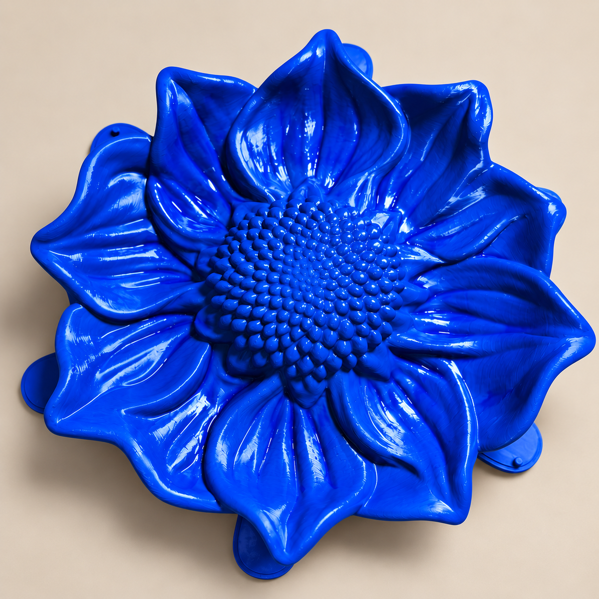 Blue sunflower mold dish on a neutral background, overhead view