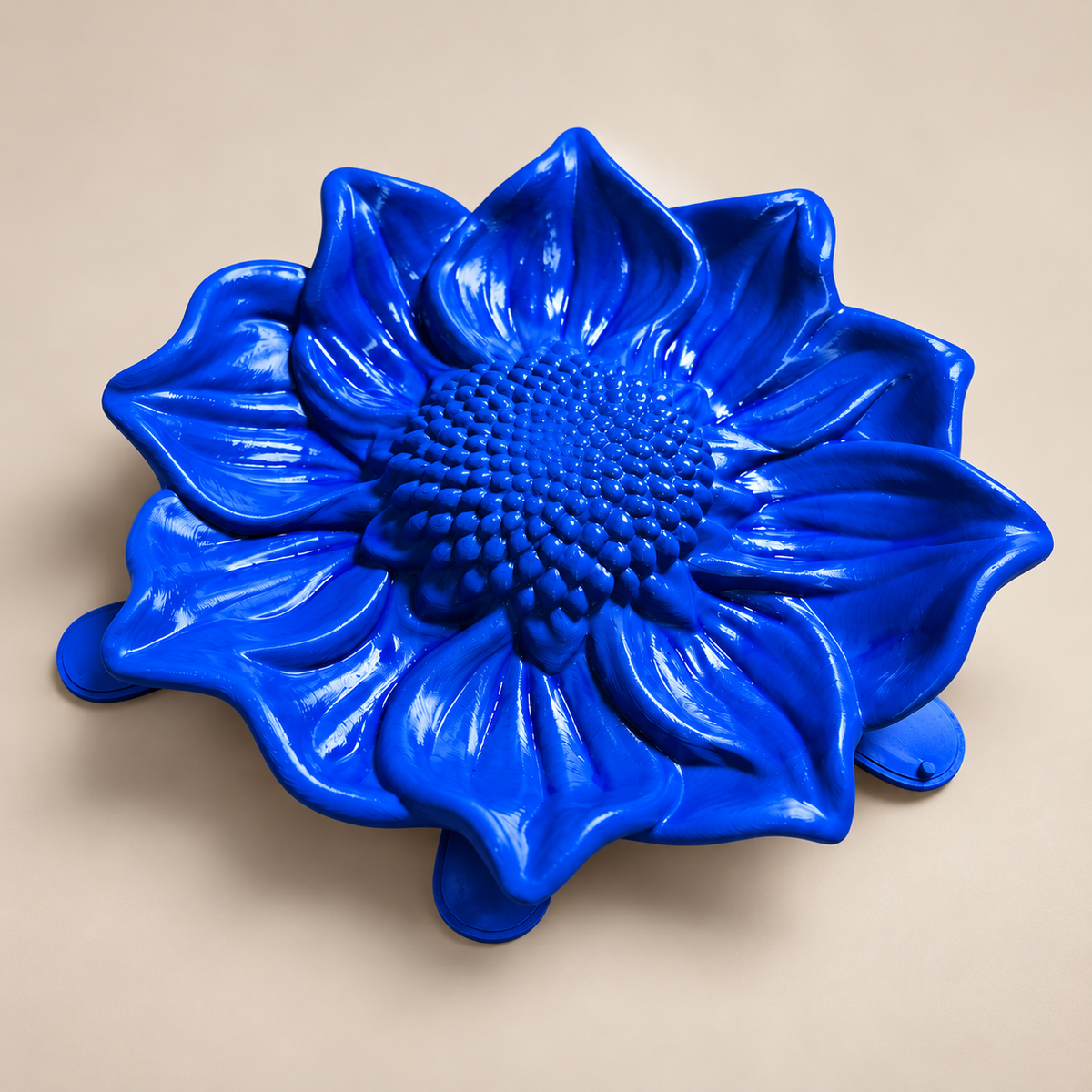 Blue sunflower mold dish on a neutral background, angled view